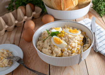 Tuna salad with mayonnaise, boiled eggs, onions and corn in a bowl
