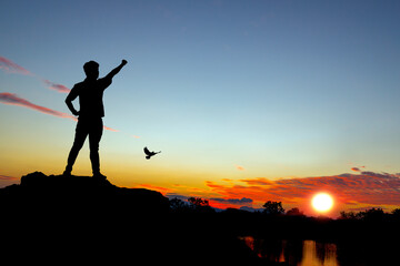 Obraz premium silhouette tourists watching the sunset on the mountain. beautiful silhouette sunset in the river view.