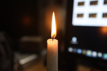 Burning candle in a room on a blurred background