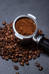 Ground coffee and coffee beans on a black background. Preparing coffee in a coffee machine.