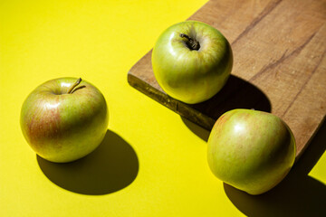 Apples on a yellow background. Fresh juicy apples. Photograph of apples in hard light