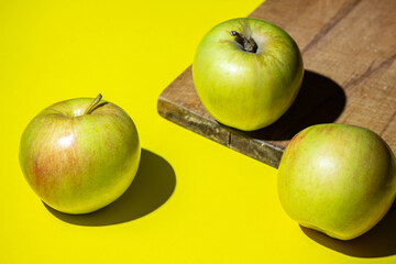 Apples on a yellow background. Fresh juicy apples. Photograph of apples in hard light