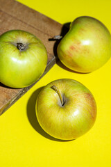 Apples on a yellow background. Fresh juicy apples. Photograph of apples in hard light