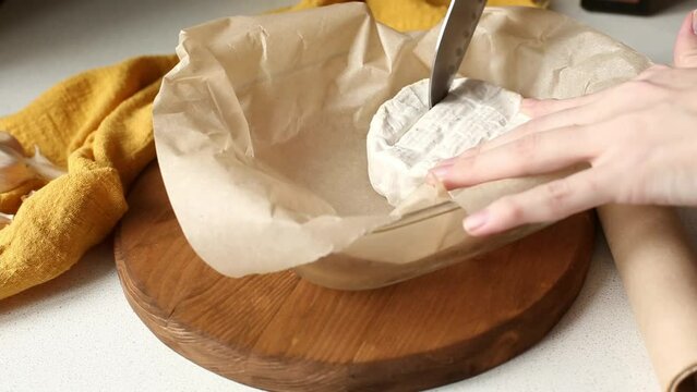 Cooking camembert with croutons in the oven. Step 1 Cut the cheese. Baked camembert with garlic sauce and spices. Cheese stretches, drips. Homemade brie in the oven.