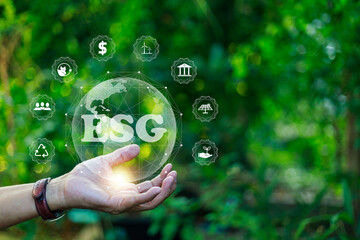 Man's hand holding a globe with ESG icon for the environment, society, and governance in sustainable and ethical business. and network connection on a green background.