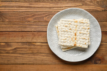 Plate with Jewish flatbread for Passover on wooden background