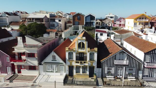 Aerial shot of coloured houses in Costa Nova do Prado in Portugal, Flying sideways in front of the houses from right to the left. Europe, Aveiro