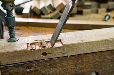 Young man doing woodworking hobby in his workshop, soft focus.