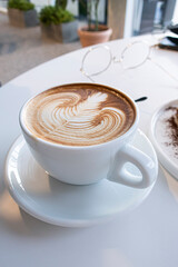 Coffee cup of rosetta latte art on white background isolated