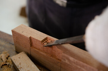 Young man doing woodworking hobby in his workshop, soft focus.