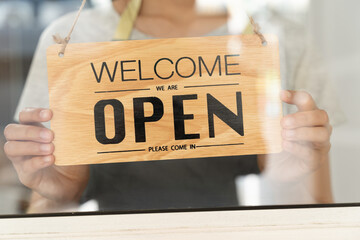 business retail owner  hanging close wooden sign board at the entrance door of the shop and ready...