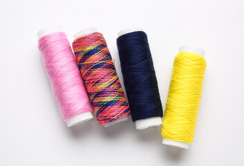 Different thread spools on white background