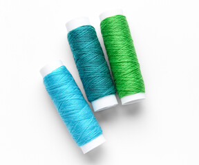 Different thread spools on white background