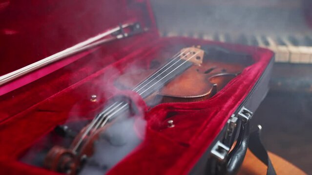 A Young Girl And Man Plays The Violin In A Beautiful Retro Room With Flowers And A Piano.