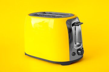 New modern toaster on yellow background