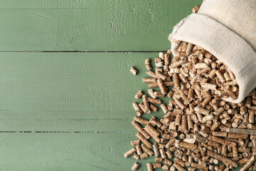 Sack bag of wood pellets on color wooden background