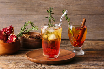 Glasses of tasty pomegranate cocktail on wooden background