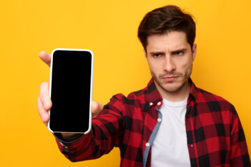 Sad guy holding showing empty smartphone screen