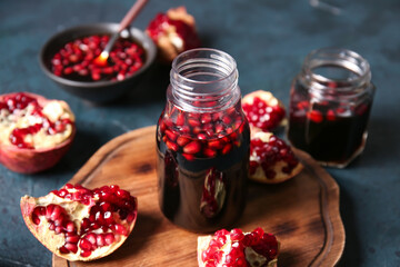 Jars of pomegranate molasses on black background