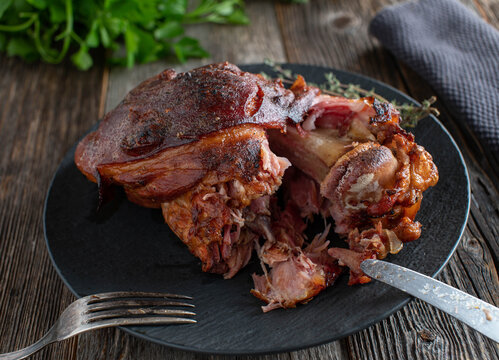 Grilled pork knuckle or ham hock on dark wooden table