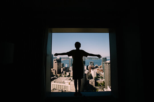 Silhouette of Boy in hotel window against  Cityscape