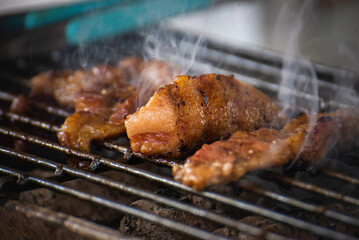 Roasting pork on a charcoal stove with smoke