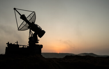 Creative artwork decoration. Silhouette of mobile air defence truck with radar antenna during...