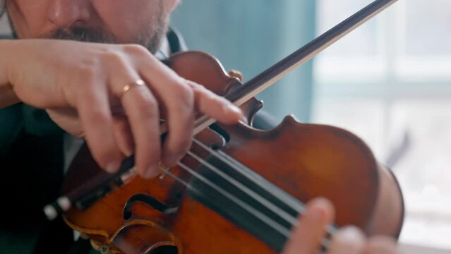 A Young Girl And Man Plays The Violin In A Beautiful Retro Room With Flowers And A Piano.