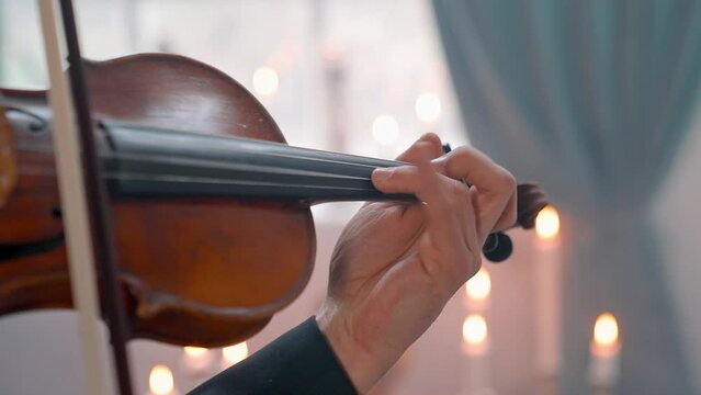 A Young Girl And Man Plays The Violin In A Beautiful Retro Room With Flowers And A Piano.