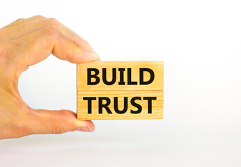 Build trust symbol. Concept words Build trust on wooden blocks on a beautiful white table white background. Businessman hand. Business and build trust concept, copy space.