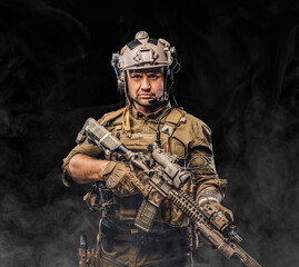 Combative soldier with serious face holding rifle against black background