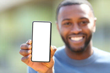 Happy man with black skin showing blank phone screen