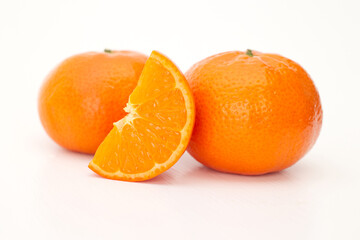 Closeup a group whole ripe orang mandarin, clementine cut half slice isolated on white background, cross section organic tangerines one piece standing front orange pile. tropical fruit with c vitamin