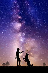 Girl trains dog at park. Woman and pet outline. Milky Way at night sky