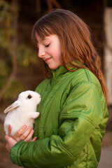 The girl is holding a white rabbit