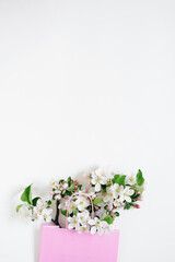 Apple tree flowers in a shopping bag on a white background with copy space. Top view and flat lay. The concept of spring discounts in stores.