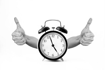 Black alarm clock with two hands thumbs up isolated on white background. 5 o'clock. Morning,...