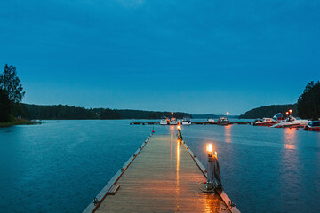 Sweden. Beautiful Wooden Pier Near Lake In Summer Evening Night. Lake Or River Landscape. Riverside