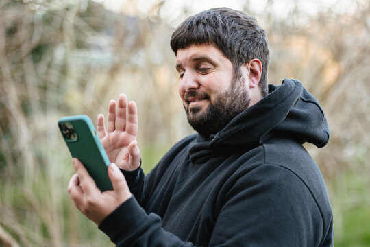 Hearing Impaired Man Waving With A Mobile Phone