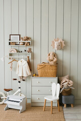 Scandinavian-style children's room: chest of drawers, bicycle, toys, piano toy, armchair and clothes on a hanger