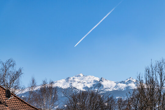 snowy mountains and contrail on blue sky - Powered by Adobe