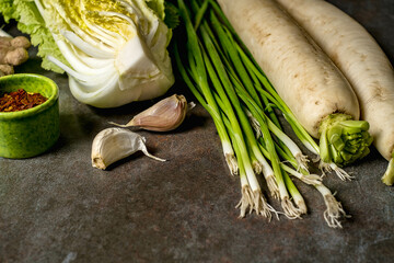 Ingredients for kimchi. Fresh vegetables, traditional Korean food in top view on wooden table copy space.