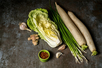 Ingredients for kimchi. Fresh vegetables, traditional Korean food in top view on wooden table copy space.