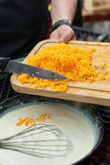 queso cheddar amarillo rallado y agregado en sarten para preparar salsa de queso  

queso cheddar 

queso 

cheddar 