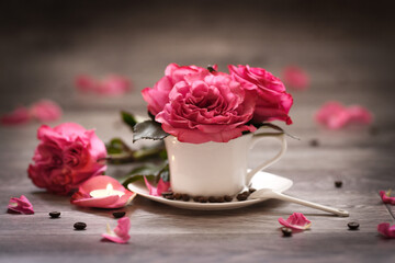 white mug on a saucer with red roses