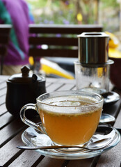 Hot ginger tea with honey in transparent glass cup 