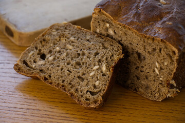 Home made sourdough bread: Fresh, home made bread after baking. Cutting board and wooden table in the background.