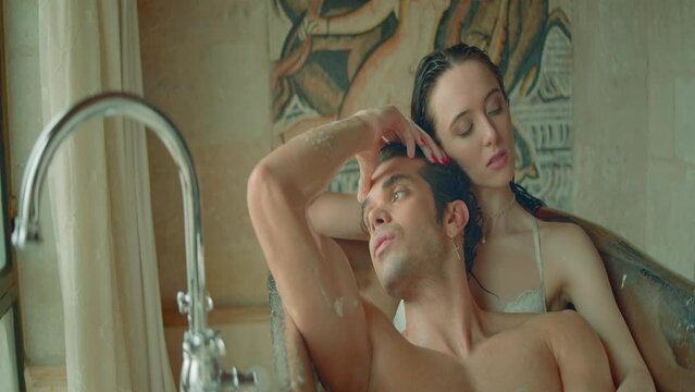 Wet couple in love in bathroom. Action. Beautiful couple in romantic photo shoot in bathroom. Happy and romantic young couple is lying in bathroom