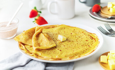 Thin pancakes bliny or crepes with homemade strawberry yogurt sauce