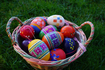 Korb mit Ostereiern steht auf einer Wiese im Garten